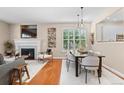 Inviting living room showcasing a fireplace, hardwood floors, and an elegant dining area at 7746 E Severn Pl, Denver, CO 80230