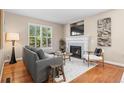 Cozy living room with a fireplace, comfortable seating, and natural light streaming through the windows at 7746 E Severn Pl, Denver, CO 80230