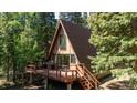 An A-frame home with a deck, perfect for enjoying the surrounding lush greenery at 100 Aspen Ln, Evergreen, CO 80439