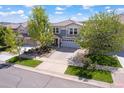 Aerial view of a gray two-story house showing the roof, front yard, driveway and street in a residential area at 2320 Morningview Ln, Castle Rock, CO 80109