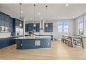Spacious kitchen featuring navy cabinets, a large island, and a dining area with a view at 14341 Beebalm Loop, Parker, CO 80134