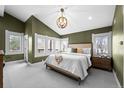 Bright bedroom featuring large windows, neutral carpet, vaulted ceilings, and stylish lighting at 2927 N Humboldt St, Denver, CO 80205