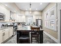 Modern kitchen with stainless steel appliances, large island, granite countertops, and white cabinetry at 2927 N Humboldt St, Denver, CO 80205