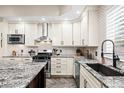 Well-appointed kitchen with stainless appliances, granite counters, white cabinets, and stylish backsplash at 2927 N Humboldt St, Denver, CO 80205