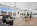 Open-concept living area with modern lighting, large windows, and combined kitchen and dining area at 610 Mosquito St, Elizabeth, CO 80107