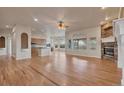 Open-concept living room with a stone fireplace and hardwood floors at 3535 Medallion Rd, Castle Rock, CO 80104