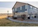 Two-story townhome with stone and siding exterior, landscaped yard, and attached garage at 12713 Leyden St # F, Thornton, CO 80602