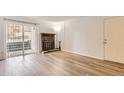 Bright living room featuring wood floors, a brick fireplace, and a sliding glass door to the outside at 7665 E Eastman Ave # 106A, Denver, CO 80231