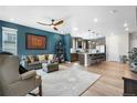 Open-concept living room with modern decor, stylish furnishings, and hardwood flooring at 16351 Askins Loop, Parker, CO 80134