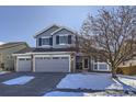 Two-story home with gray siding and a three-car garage at 16424 E 107Th Pl, Commerce City, CO 80022