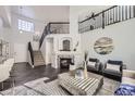 Bright living room with high ceilings and a fireplace at 16424 E 107Th Pl, Commerce City, CO 80022