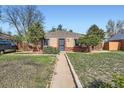 Charming brick home featuring a well-maintained lawn and walkway leading to the front door at 2220 Quebec St, Denver, CO 80207