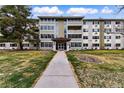 Exterior of well-maintained mid-rise apartment building with landscaped lawn and mature trees at 750 S Alton Way # 9B, Denver, CO 80247