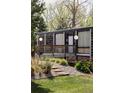 Charming house with wood facade, lush green lawn, mature trees, and inviting wood deck offering a peaceful outdoor setting at 7170 W 8Th Pl, Lakewood, CO 80214