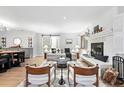Open-concept living room featuring a painted brick fireplace, natural light, and access to dining and sitting area at 11 S Albion St, Denver, CO 80246
