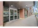 Modern apartment building entrance with glass doors, brick accents, and sidewalk access at 1401 Wewatta St # 709, Denver, CO 80202