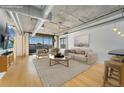 Modern living room with hardwood floors, industrial ceiling, city views, and neutral furniture at 1401 Wewatta St # 709, Denver, CO 80202