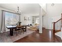 Open concept dining area with hardwood floors and modern chandelier at 12773 E 105 Th Pl, Commerce City, CO 80022