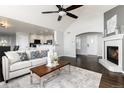 Bright living room features a fireplace, vaulted ceiling and dark hardwood flooring at 3430 Deer Creek Dr, Parker, CO 80138