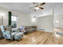 Bright living room featuring hardwood floors, a ceiling fan, and neutral-colored furniture at 2659 S Halifax St, Aurora, CO 80013