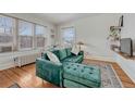 Inviting living room showcasing a stylish velvet sofa, hardwood floors, and natural light streaming through large windows at 1100 N Marion St # 4, Denver, CO 80218