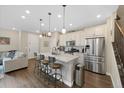 Bright, open kitchen featuring stainless steel appliances, island seating, wood floors and adjacent Gathering room at 7579 S Zante Ct, Aurora, CO 80016