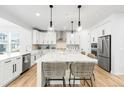 Bright, open kitchen with white cabinets, large center island, and stainless steel appliances at 777 Gold Hill Dr, Erie, CO 80516