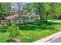 Well-maintained front yard with lush green grass and mature trees surrounding the home at 2 Elm St, Denver, CO 80220