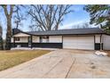 Inviting single-story home featuring a two-car garage, dark brick accents, and a cozy front entrance at 6948 W 70Th Ave, Arvada, CO 80003