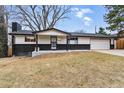 Cozy single-story house with a well-kept lawn, dark brick accents, and an attached two-car garage at 6948 W 70Th Ave, Arvada, CO 80003