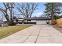 Attractive single-story home with dark brick accents, a two-car garage, and a spacious driveway at 6948 W 70Th Ave, Arvada, CO 80003