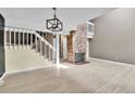 Bright living room with hardwood floors, brick fireplace, and open staircase at 14204 E Radcliff Cir, Aurora, CO 80015