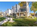 Beautiful exterior view of townhomes with manicured lawn, lovely landscaping, and a charming balcony at 888 S Valentia St # 104, Denver, CO 80247
