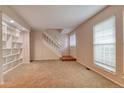 Bright living room featuring carpet floors, and a staircase leading to the upper level at 10320 E Jewell Ave # 63, Aurora, CO 80247