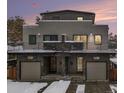 Modern duplex with gray siding, attached garages, and snowy front yard at 1449 Ivy St, Denver, CO 80220