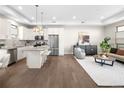 Open concept living area with stainless appliances, hardwood floors, island with bar seating, and modern furnishings at 5360 Allison St # D, Arvada, CO 80002
