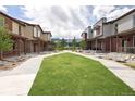 A community greenspace between townhomes, with sidewalks, grass and low-maintenance landscaping at 11228 Bella Vita Dr, Broomfield, CO 80020