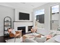 Bright living room with a modern fireplace, comfortable seating, and large windows offering neighborhood views at 3131 Vallejo St, Denver, CO 80211