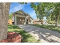Well-maintained home with beautiful lawn and long driveway leading to an attached garage at 17499 E Whitaker Dr, Aurora, CO 80015
