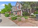 Street view of a well-maintained townhouse with a red door and landscaped front yard at 1035 Milo Cir # B, Lafayette, CO 80026