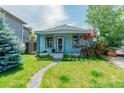 Inviting home with a quaint front porch, colorful landscaping, and a well-manicured lawn at 4079 S Bannock St, Englewood, CO 80110