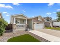 Inviting home showcasing a cozy front porch and a neatly maintained front yard at 2034 Espana Way, Aurora, CO 80011