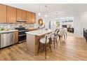 Spacious kitchen with an island, stainless steel appliances, and an open view to the living room at 2034 Espana Way, Aurora, CO 80011