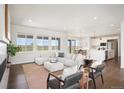 Open concept living room featuring a comfortable sectional sofa, stylish decor, and seamless kitchen access at 14391 Shasta Daisy Pt, Parker, CO 80134