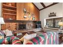 Living room featuring a stone fireplace, wood paneled wall, and built-in shelves for storage at 107 N Harris St # 306, Breckenridge, CO 80424