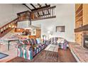 Spacious living room features a fireplace, wood paneling, and view of the kitchen and upstairs at 107 N Harris St # 306, Breckenridge, CO 80424