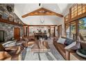 Bright and airy living room with vaulted ceiling, wood beams, and large windows at 6016 Stone Creek Dr, Evergreen, CO 80439