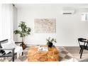 A cozy living room with a textured rug, wood accent table, and stylish decorative plants at 3955 W 13Th Ave, Denver, CO 80204