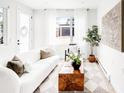 Bright living room featuring a stylish white sofa, wood accent table, and contemporary decor at 3955 W 13Th Ave, Denver, CO 80204