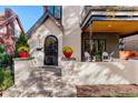 Inviting front porch with brick accents, wrought iron door, and cheerful flowerpots, creating a warm entrance at 536 S Vine St, Denver, CO 80209